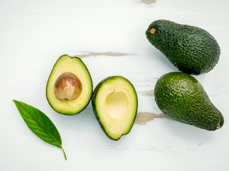 Close Up fresh avocado and leaves on white shabby wooden background.の写真素材