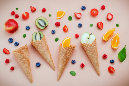 Cones and colorful various fruits raspberry ,blueberry ,strawberry ,orange slice , halve kiwi...