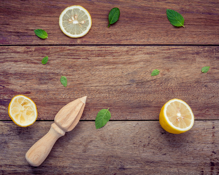 Fresh lemon and wooden juicer for summer juice and cocktail. Fresh lemon sliced and peppermint leaves set up on shabby wooden background flat lay.の写真素材