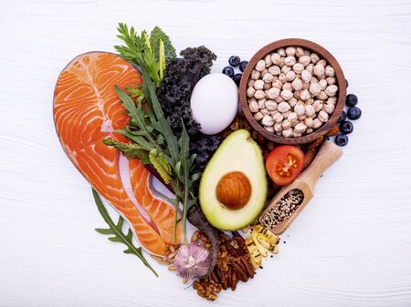 Heart shape of ketogenic low carbs diet concept. Ingredients for healthy foods selection on white woodenの写真素材