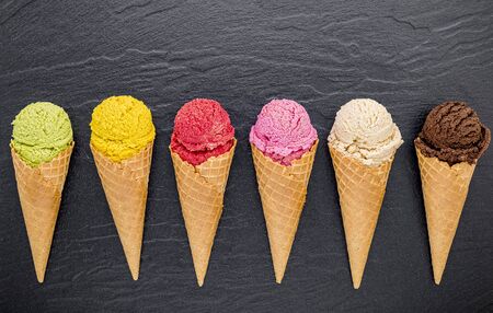 Various of ice cream flavor in cones on dark stoneの写真素材