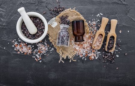 Himalayan black salt and Himalayan pink salt on dark concrete background. Himalayan salt commonly used in cooking and for bath products such as bath salts.の写真素材