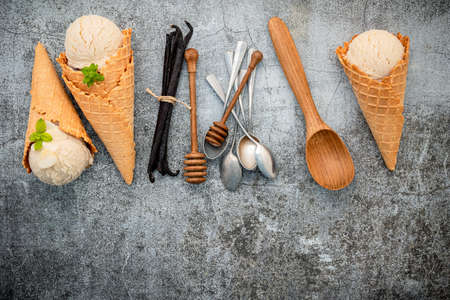 Vanilla ice cream flavor in cones with Vanilla pods setup on concrete background . Summer and Sweet menu concept.の写真素材