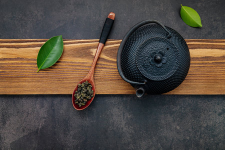 Black cast iron tea pot with herbal tea set up on dark stone background.の写真素材