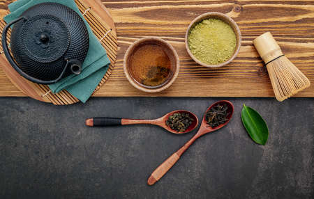 Black cast iron tea pot with herbal tea set up on dark stone background.の写真素材