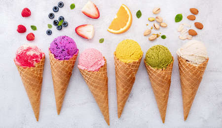 Various of ice cream flavor in cones blueberry ,pistachio ,almond ,orange and cherry setup on white...