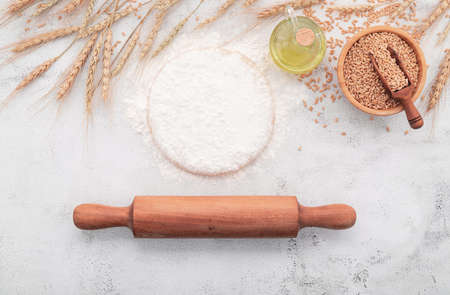 The ingredients for homemade pizza dough with wheat ears ,wheat flour and wheat grains set up on...