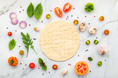 The ingredients for homemade pizza set up on white marble background with copy space and top view.の写真素材