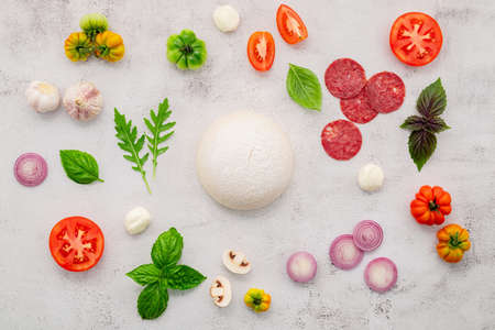 The ingredients for homemade pizza set up on white concrete background.の写真素材