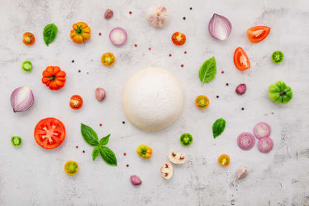 The ingredients for homemade pizza set up on white concrete background.の写真素材