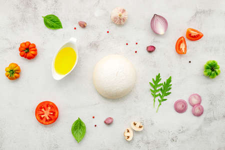 The ingredients for homemade pizza set up on white concrete background.の写真素材
