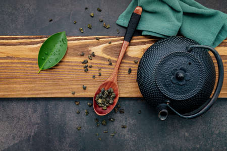 Black cast iron tea pot with herbal tea set up on dark stone background.の写真素材