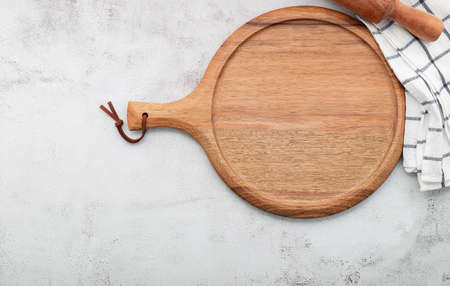 Empty wooden pizza platter set up on white concrete. Pizza board on white concrete background flat lay and copy space.の写真素材