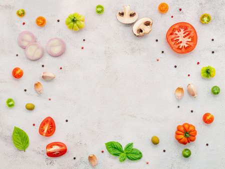 The ingredients for homemade pizza set up on white concrete background.の写真素材