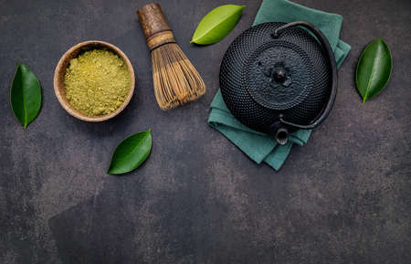 Black cast iron tea pot with herbal tea set up on dark stone background.の写真素材