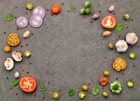The ingredients for homemade pizza set up on dark stone background.の写真素材