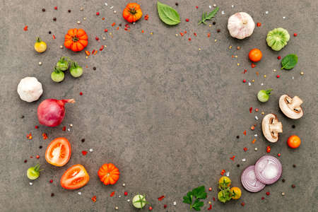 The ingredients for homemade pizza set up on dark stone background.の写真素材
