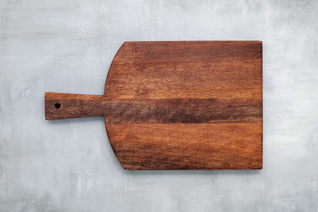 Empty vintage wooden cutting board set up on concrete background with copy space.の写真素材