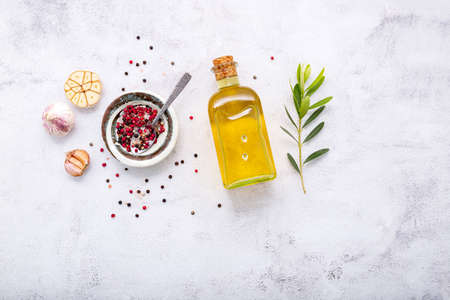 Glass bottle of olive oil and olive branch set up on white concrete background.の写真素材