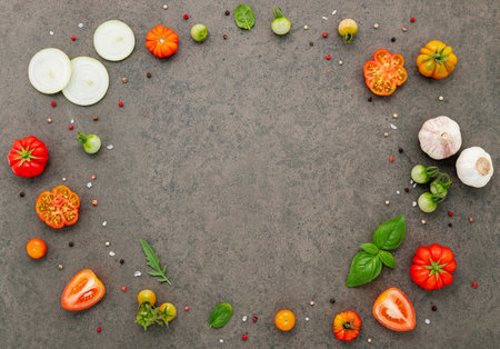 The ingredients for homemade pizza set up on dark stone background.の写真素材