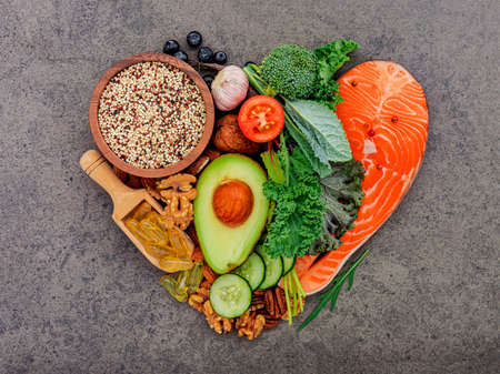 Heart shape of ketogenic low carbs diet concept. Ingredients for healthy foods selection on dark stone background.の写真素材