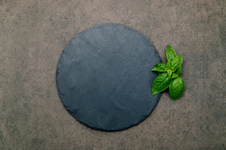 Empty pizza platter for homemade baking set up on dark concrete. Food recipe concept on dark stone background texture with copy space.の写真素材