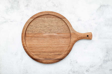 Empty wooden pizza platter set up on white concrete. Pizza board on white concrete background flat lay and copy space.の写真素材