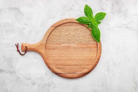 Empty wooden pizza platter set up on white concrete. Pizza tray on white concrete background flat lay and copy space.の写真素材