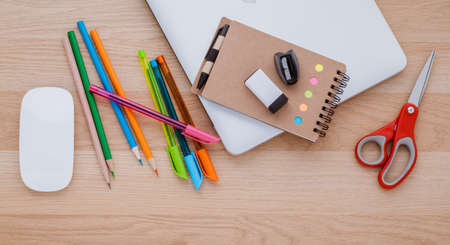 Back to school concept with school supplies laptop ,book, pen,mouse,and colored pencil on wooden table .の写真素材