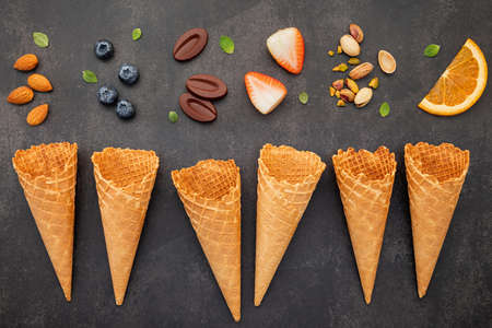 Flat lay ice cream cones collection on dark stone background . Blank crispy ice cream cone with copy space for sweets menu design.の写真素材