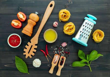 The  pasta on black wooden background. Yellow italian pasta with ingredients. Italian food and menu concept.の写真素材