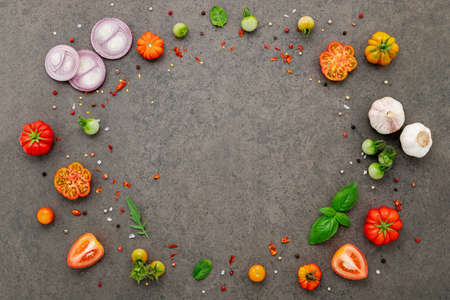 The ingredients for homemade pizza set up on dark stone background.の写真素材
