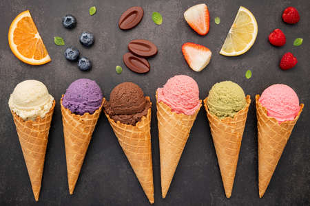 Flat lay ice cream cones collection on dark stone background . Blank crispy ice cream cone with copy space for sweets menu design.の写真素材