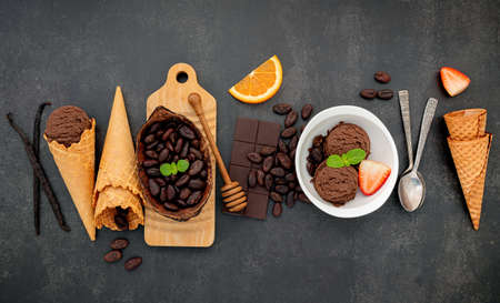 Chocolate ice cream flavours in bowl with dark chocolate and cacao nibs setup on dark stone background .の写真素材