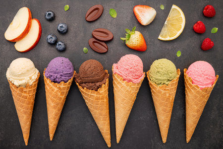 Flat lay ice cream cones collection on dark stone background . Blank crispy ice cream cone with copy space for sweets menu design.の写真素材