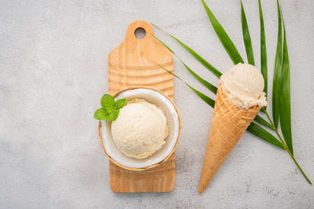 Coconut ice cream flavours in half of coconut setup on white stone background. Summer and Sweet menu concept.の写真素材