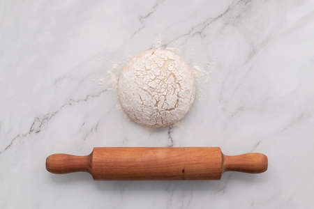 Fresh homemade yeast dough resting on marble table flat lay with rolling pin.の写真素材