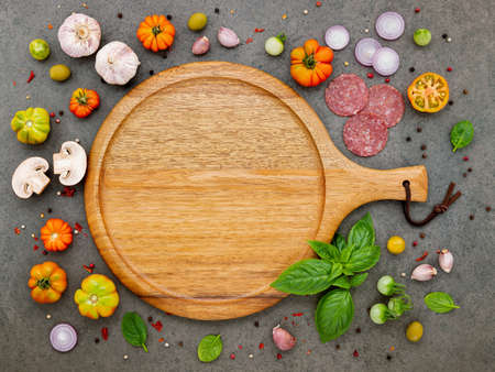 The ingredients for homemade pizza set up on dark stone background.の写真素材