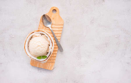 Coconut ice cream flavours in half of coconut setup on white stone background. Summer and Sweet menu concept.の写真素材