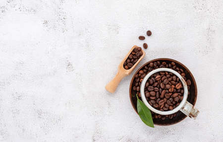 Roasted coffee beans with scoops setup on white concrete background.の写真素材