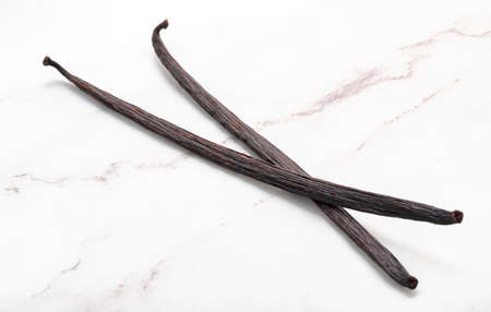 Dried vanilla sticks set up on marble background.の写真素材