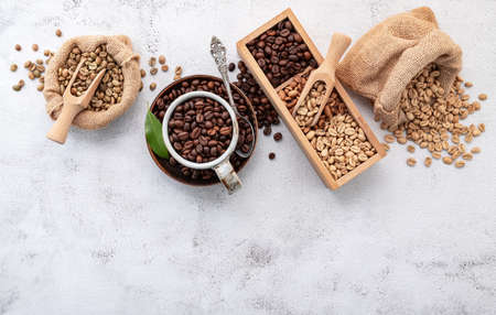 Roasted coffee beans with scoops setup on white concrete background.の写真素材