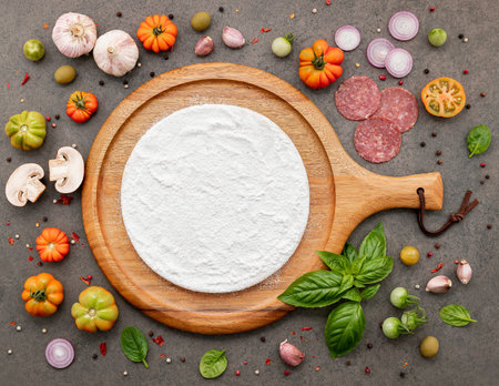 The ingredients for homemade pizza set up on dark stone background.の写真素材