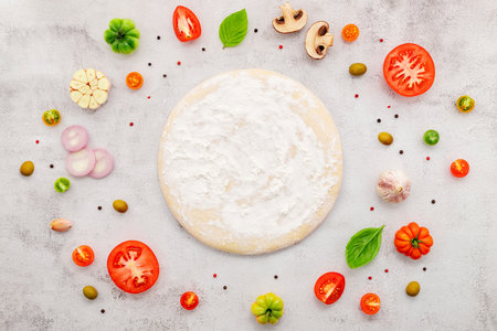 The ingredients for homemade pizza set up on white concrete background.の写真素材