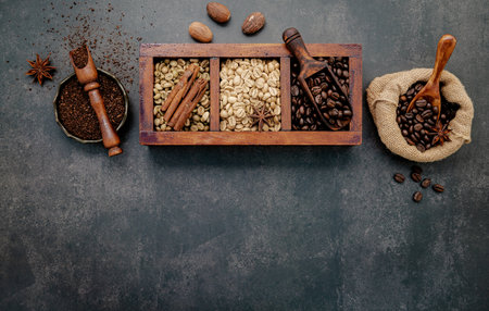 Roasted coffee beans with coffee powder and flavourful ingredients for make tasty coffee setup on dark stone background.の写真素材
