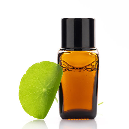 Close up centella asiatica extract in amber bottle with centella asiatica leaves isolated on white background.の写真素材
