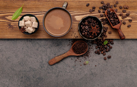 Roasted coffee beans with coffee cup setup on dark stone background.の写真素材