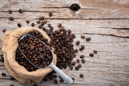 Background of dark roasted coffee beans with scoops setup on wooden background with copy space.の写真素材