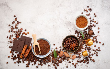 Background of various coffee , dark roasted coffee beans , ground and capsules with scoops setup on white concrete background with copy space.の写真素材