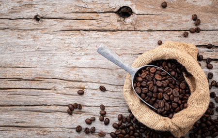 Background of dark roasted coffee beans with scoops setup on wooden background with copy space.の写真素材